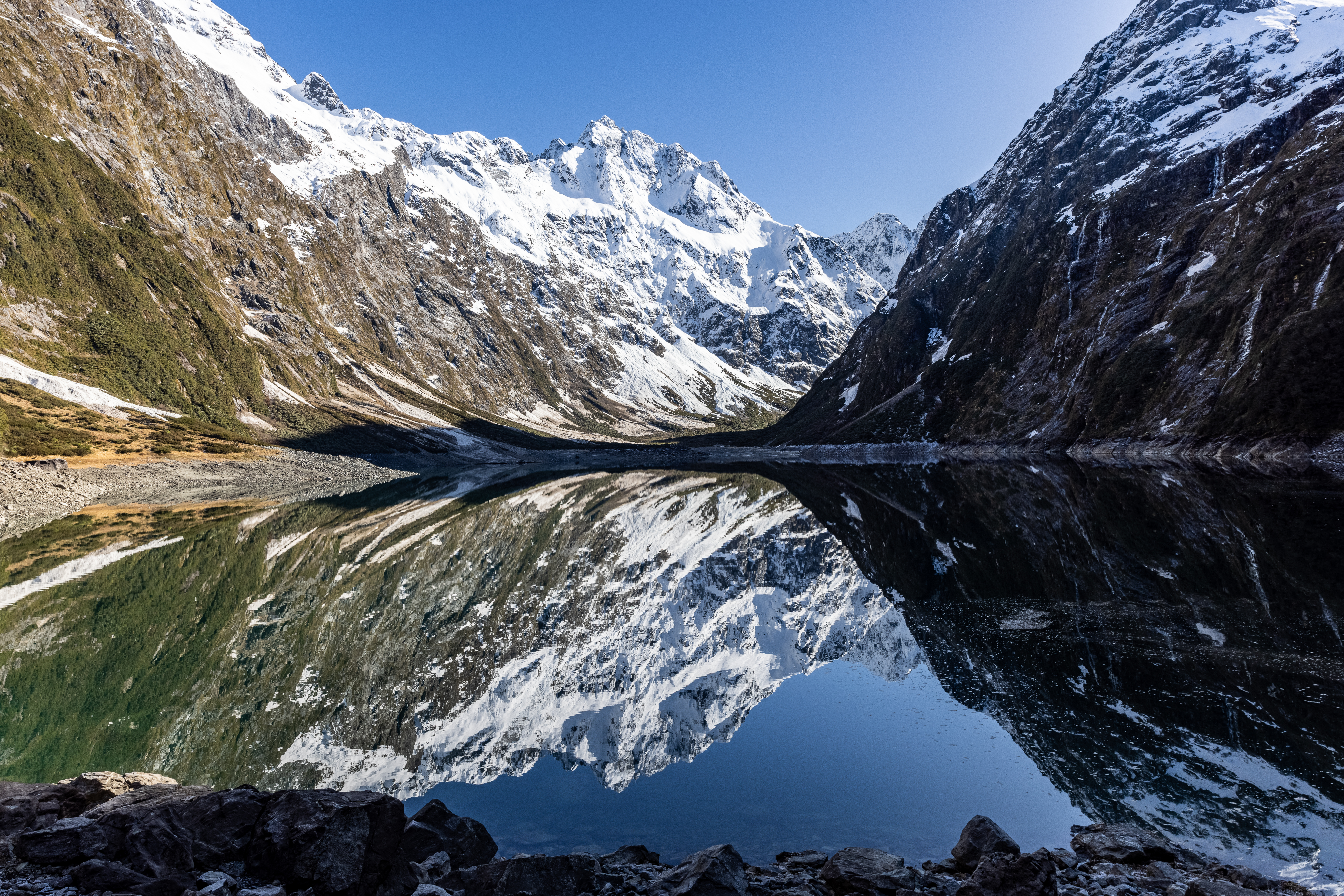 Snowy mountain peaks reflected in a still alpine lake