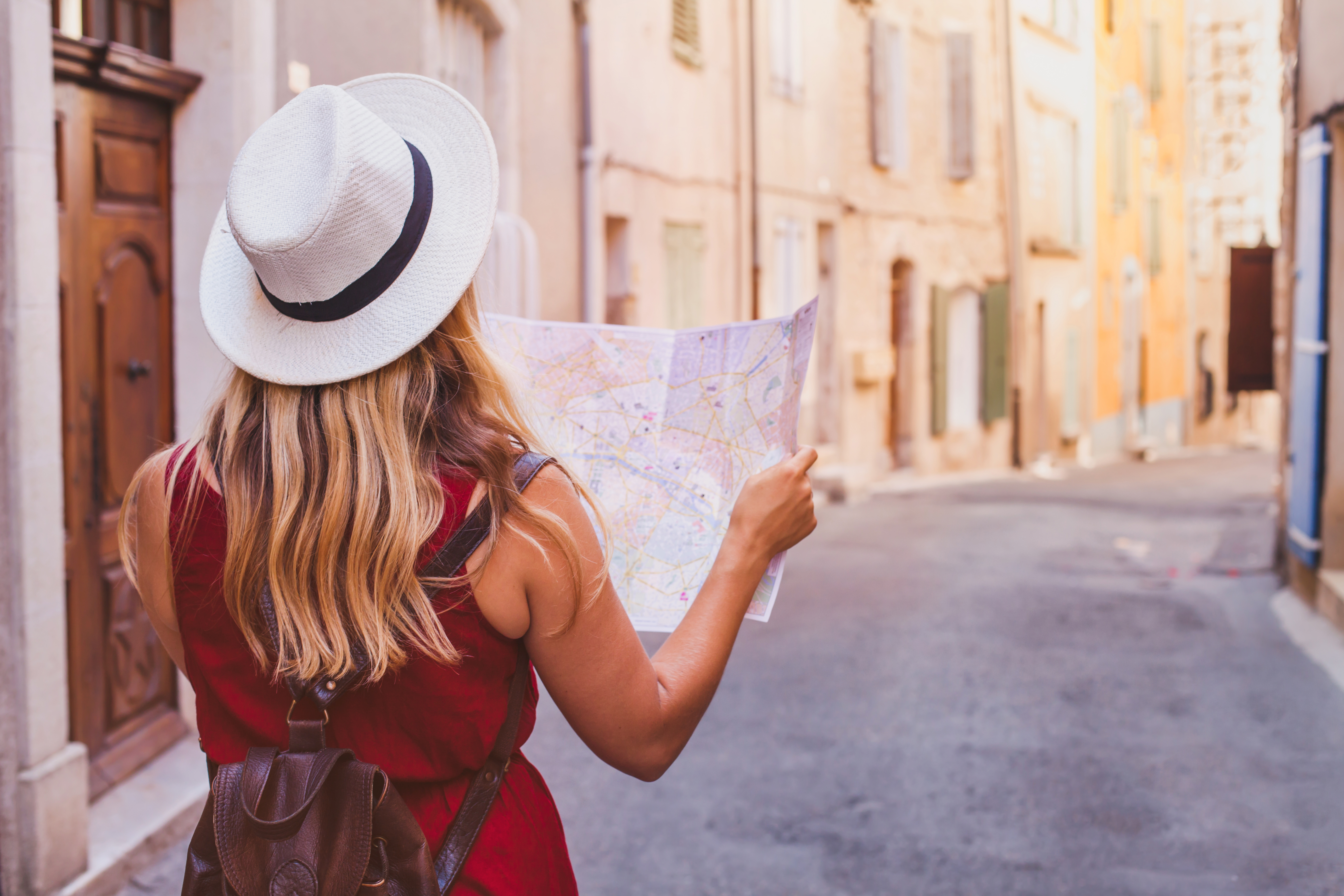 Traveller with a map walking through an old city street