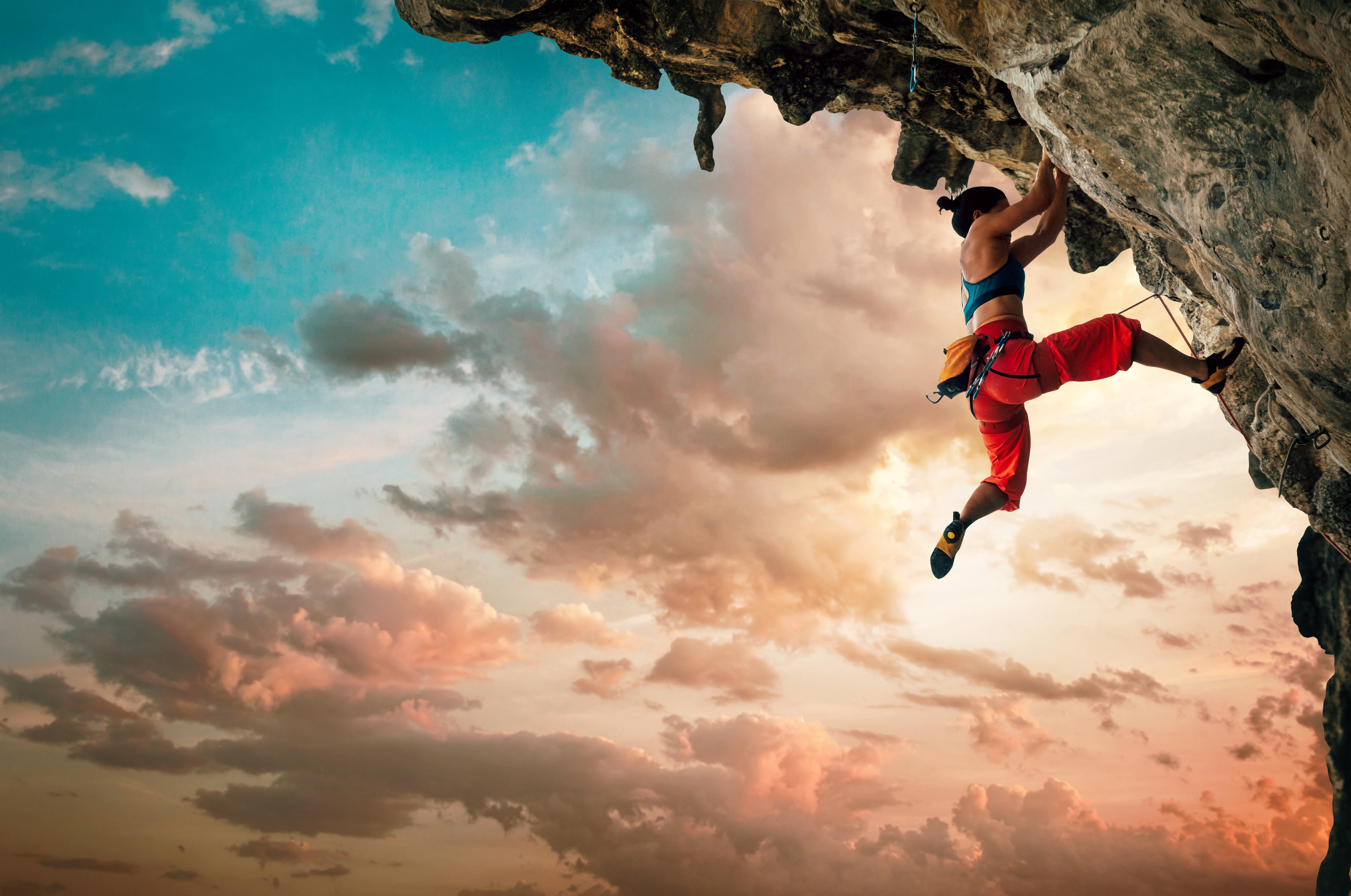 Rock climber on a cliff at sunset