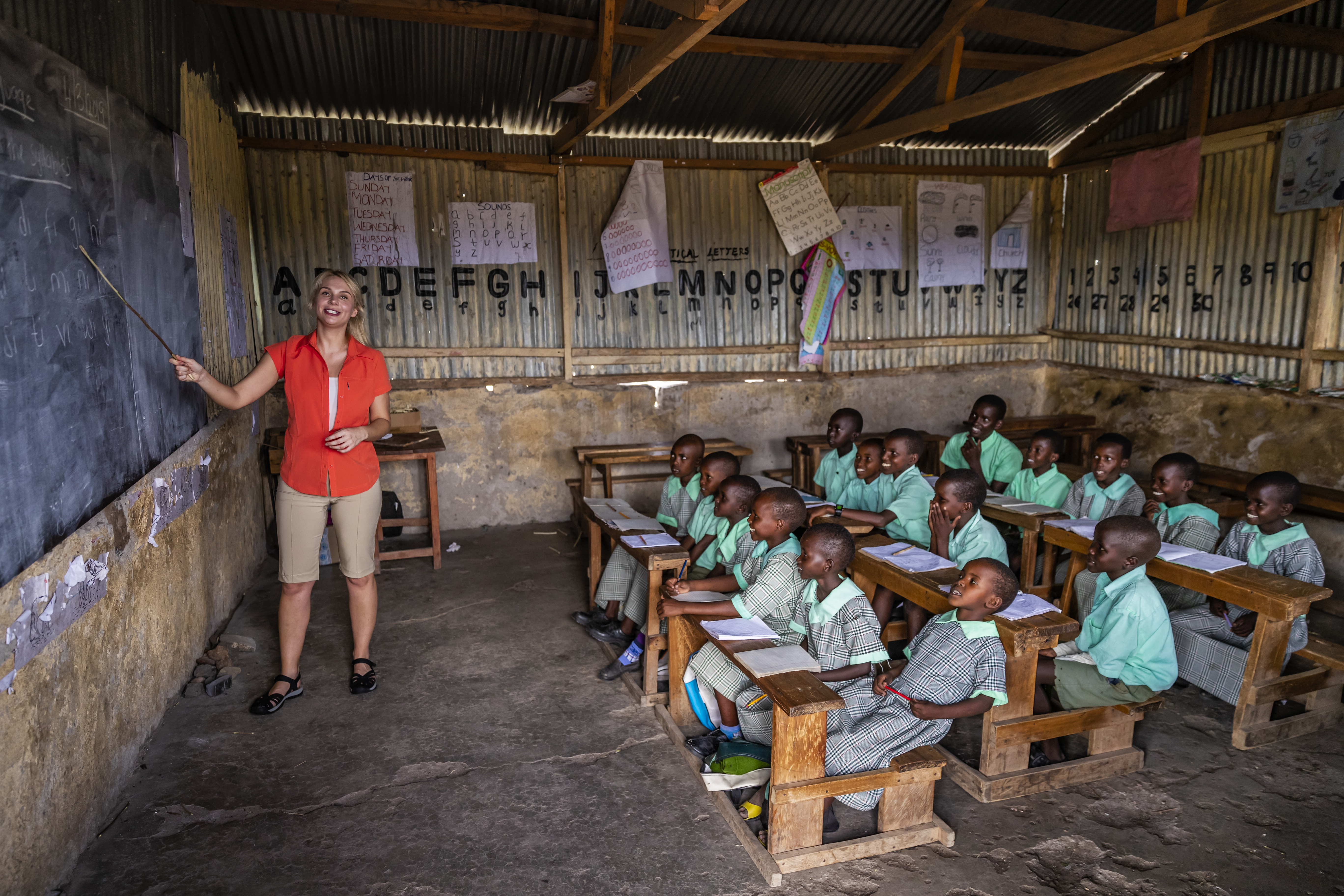 Volunteer teacher supporting children in a community classroom