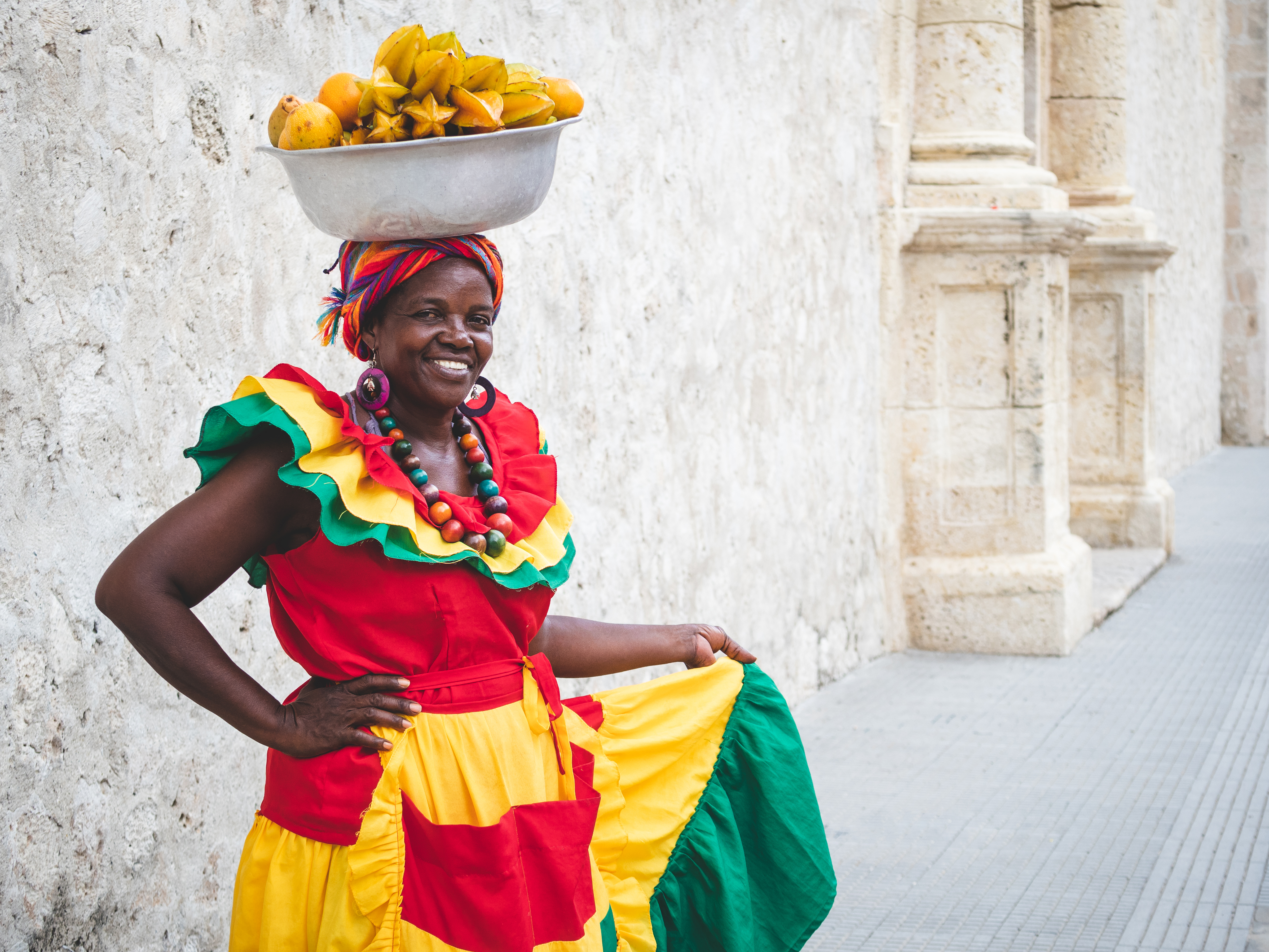 Traditional fruit vendor in colourful clothing in Cartagena