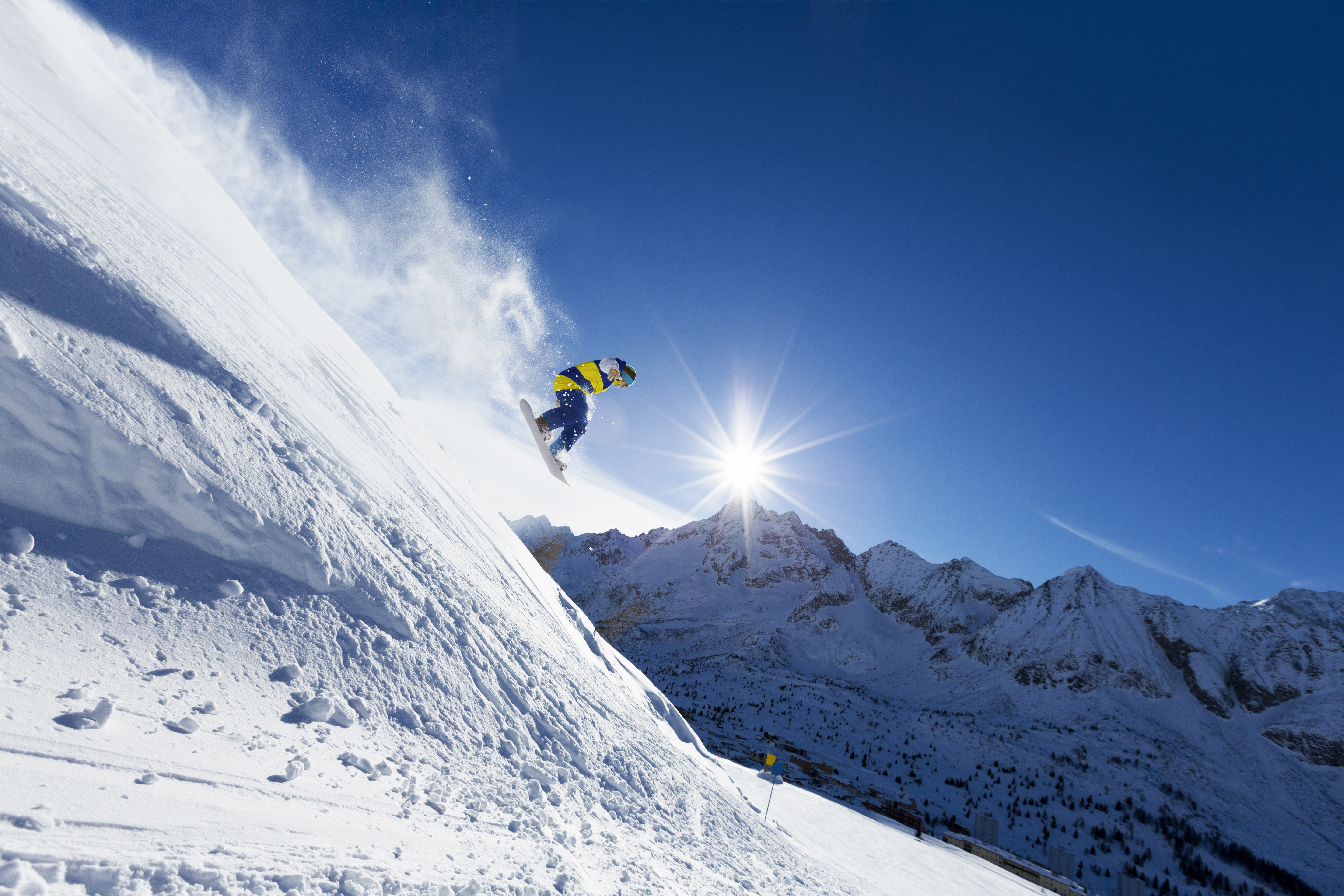 Snowboarder riding through fresh mountain snow