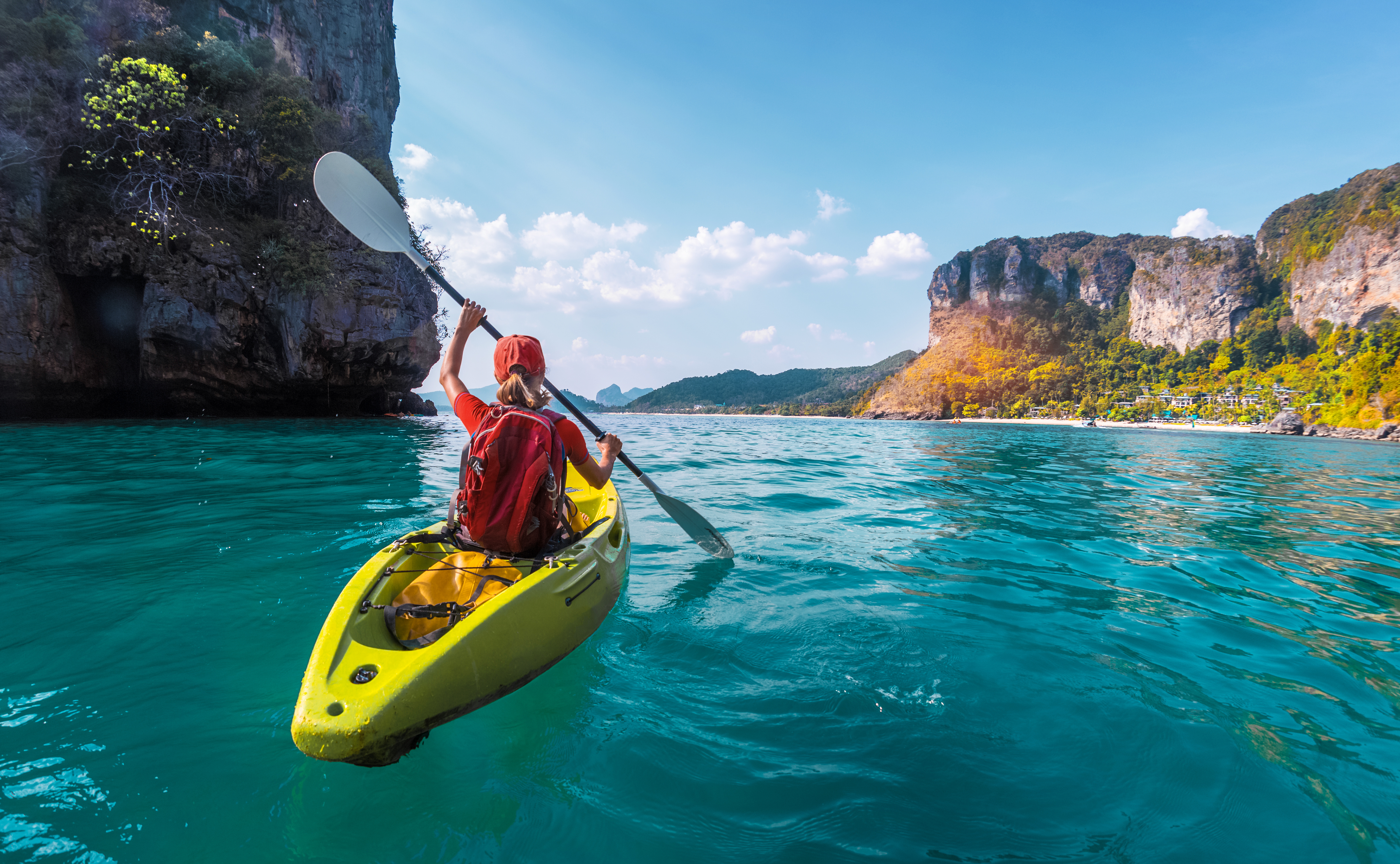 Woman kayaking along a tropical coastline