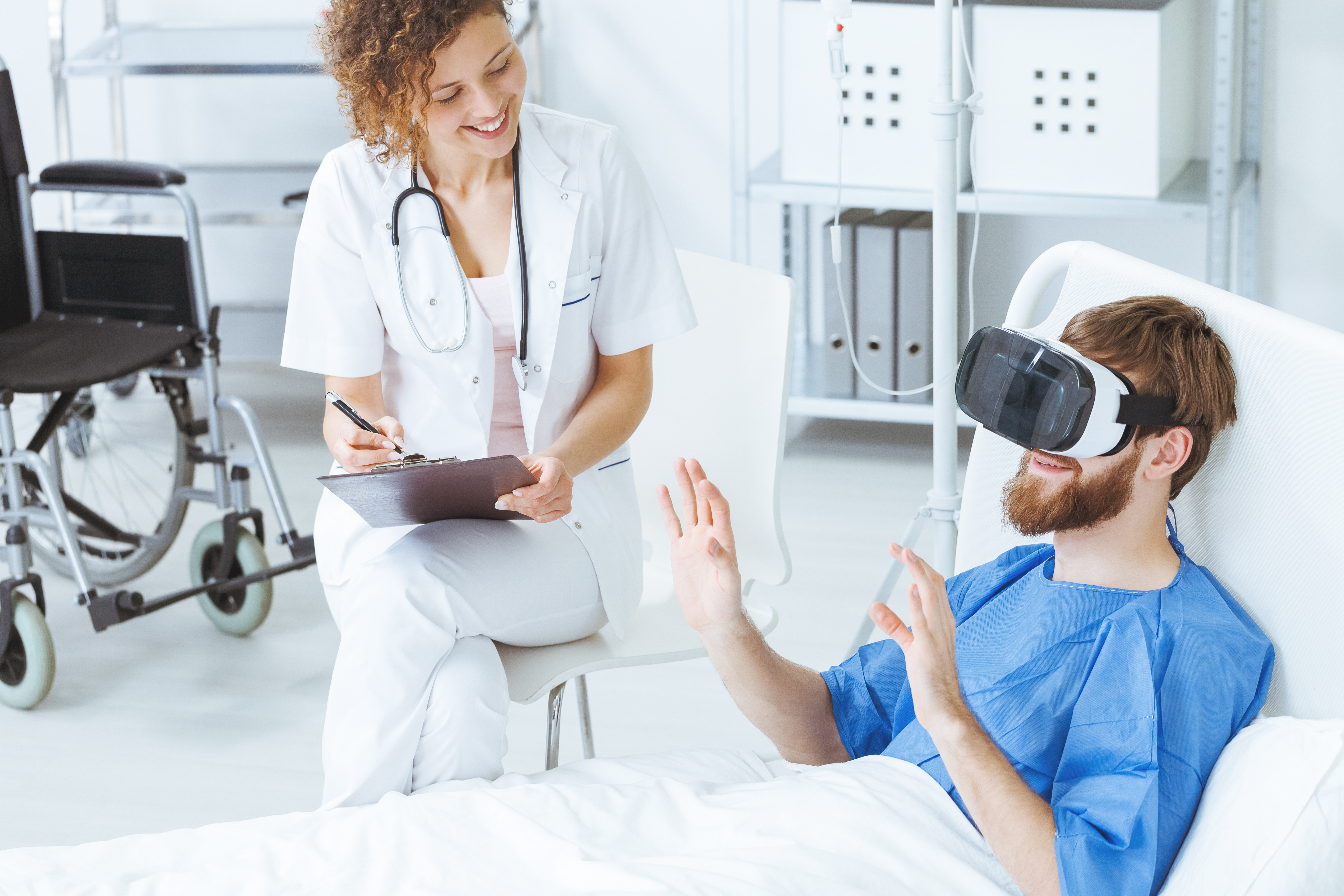 Patient wearing virtual reality goggles in hospital with a clinician nearby
